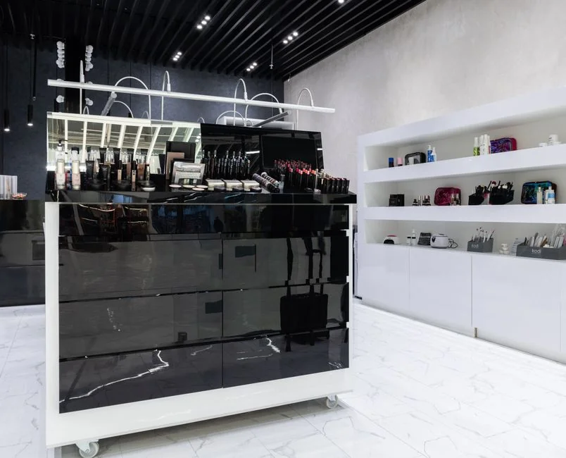 Personne utilisant un vaporisateur et un chiffon pour nettoyer une étagère de cuisine, en veillant à l’hygiène et à la propreté.